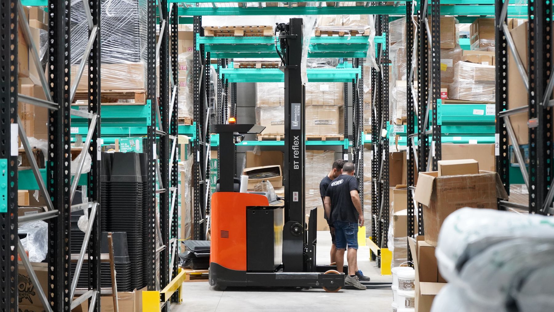 Forklift moving stock through a warehouse aisle