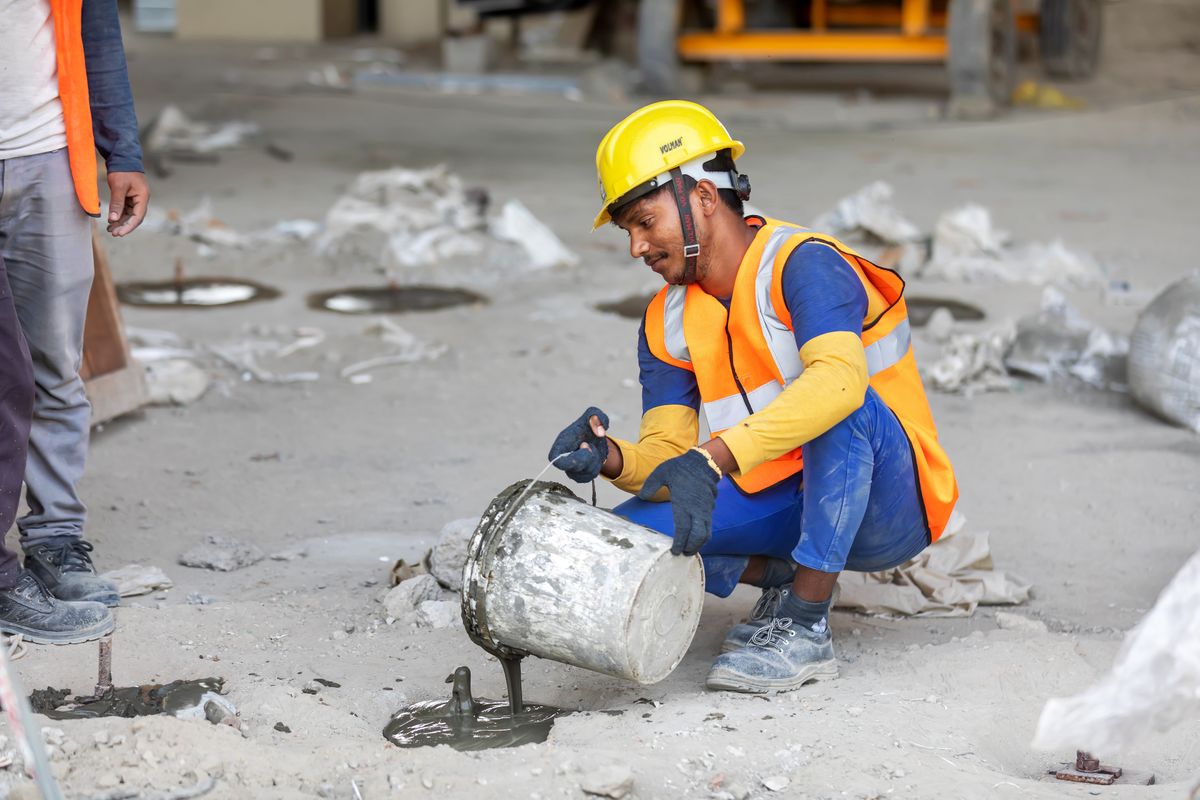 Construction worker pouring concrete on site