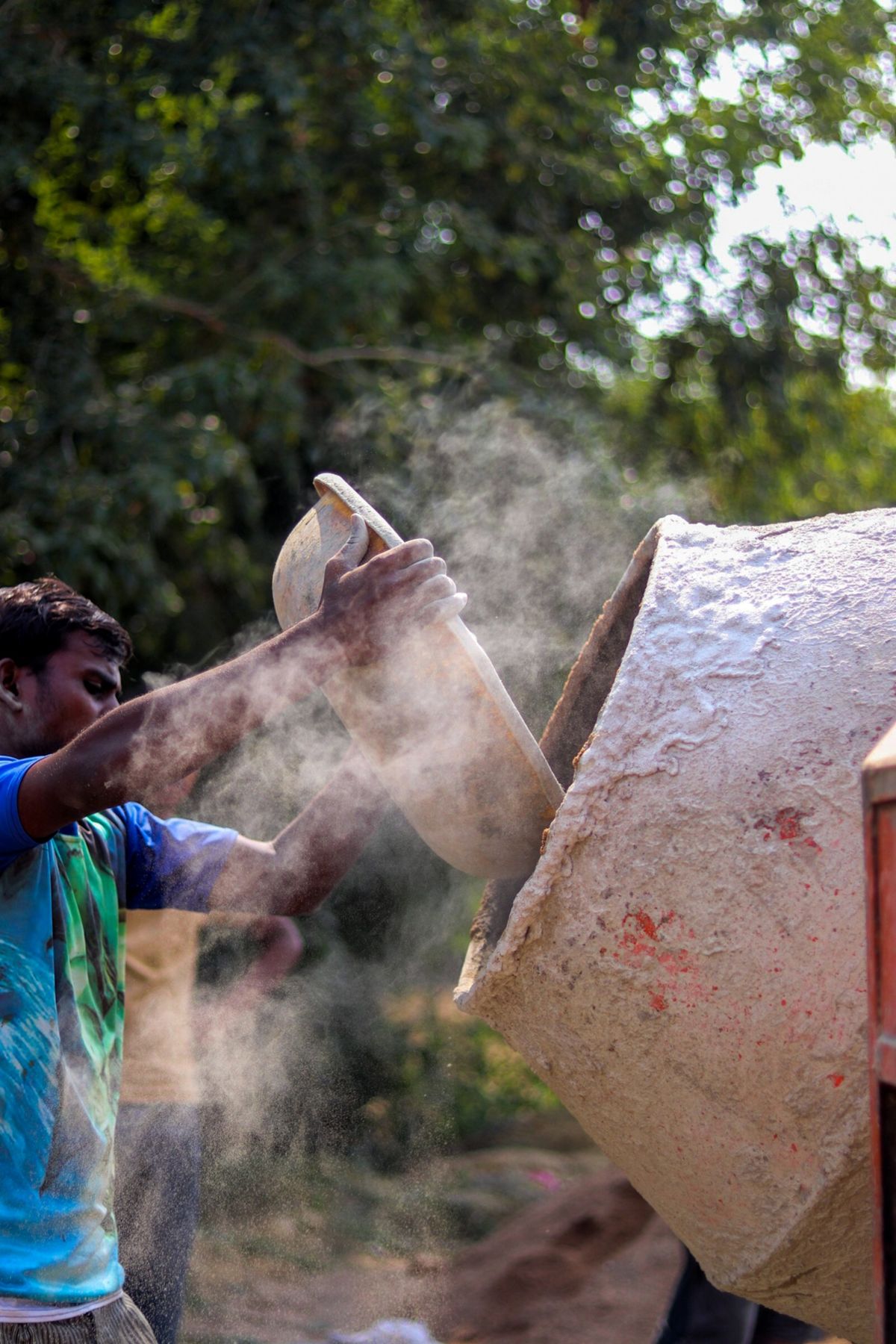 Worker emptying powder into a mixer
